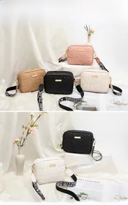 Detailed view of colorful quilted camera bags with wide patterned crossbody straps