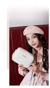 Detail view of ivory white quilted crossbody bag with golden metal buckle and thin strap