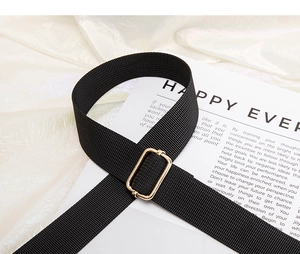 Close-up of black nylon crossbody strap with premium gold metal adjustable buckle