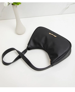 Close-up of black lychee grain texture and gold logo on minimalist underarm bag