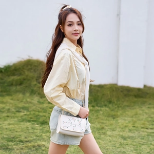 Cream embroidery chain bag with floral pattern shown on shoulder by a woman