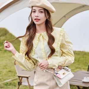 Classic white quilted crossbody bag with silk scarf on handle for elegant outdoor styling