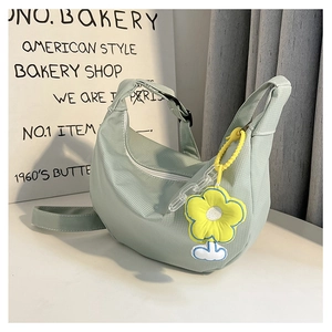 Détail du sac hobo vert menthe avec breloque tournesol jaune et fermeture éclair blanche