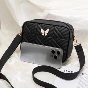 Black quilted crossbody camera bag featuring a white butterfly ornament and wide strap