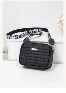 Macro shot of black checkered leather bag featuring stylish wide lettered shoulder strap