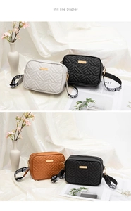 Detail of quilted camera bag with gold hardware and stylish lettered crossbody strap