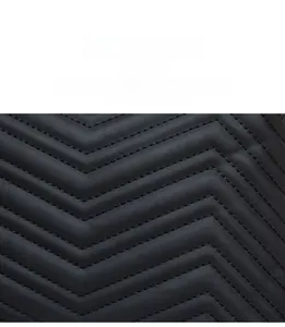 Close-up of black V-shaped quilted leather texture and wide shoulder strap detail