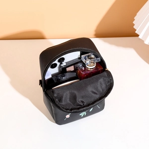 Floral embroidered black crossbody phone bag showing spacious interior with cosmetics