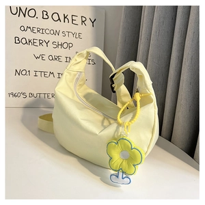 Détail du sac croissant jaune clair avec breloque fleur jaune et boucle noire réglable