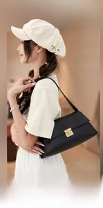 Détail d'un élégant sac baguette en cuir noir doté d'un fermoir en métal doré carré