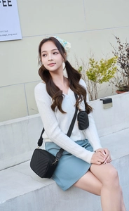 Detail of black V-quilted camera bag with matching small coin purse and woven strap