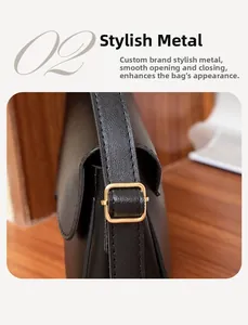 Vue détaillée de la boucle en métal doré et de la bandoulière en cuir noir du sac