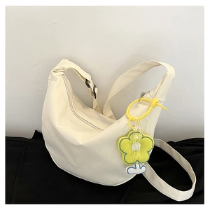Détail du sac bandoulière beige minimaliste en forme de croissant avec fleur jaune