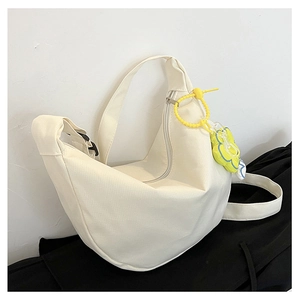 Détail du sac croissant en velours côtelé crème avec breloque fleur jaune et fermeture