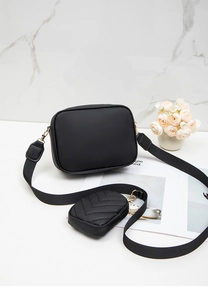 Detail of black two-in-one crossbody bag with wide webbing strap and quilted coin purse