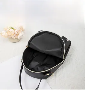 Top view of black pebbled leather backpack showing spacious interior with golden hardware