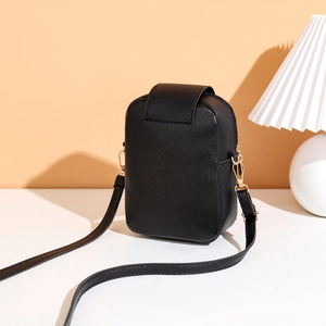 Minimalist black embroidery crossbody phone bag with gold hardware on white surface