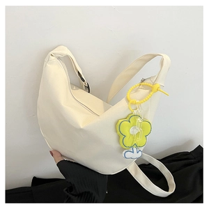 Détail du sac bandoulière demi-lune blanc cassé avec breloque fleur jaune et fermeture éclair