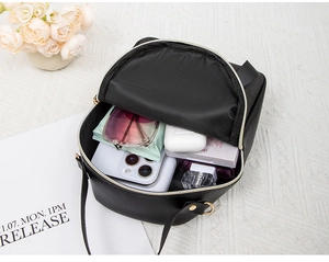 Top view of compact black faux leather backpack showing large internal storage capacity