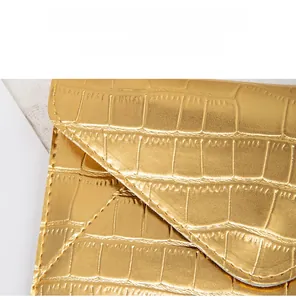 Detail of gold faux leather crossbody bag showing crocodile texture and fine stitching