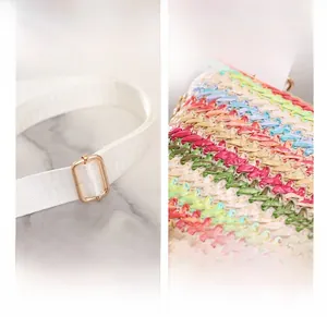 Détail de la bandoulière blanche réglable et boucle dorée sur sac en paille tissé
