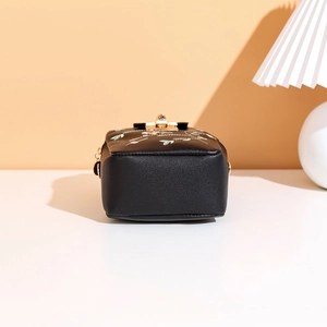 Close-up of black leather crossbody bag with floral embroidery and golden metal lock
