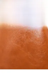 Macro shot of premium oil-wax leather texture with natural grain on caramel backpack