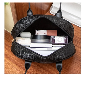 Interior view showing the large capacity of the black pebble leather handbag with daily items