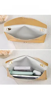 Detail of stone pattern envelope clutch showing spacious interior with cards and phone