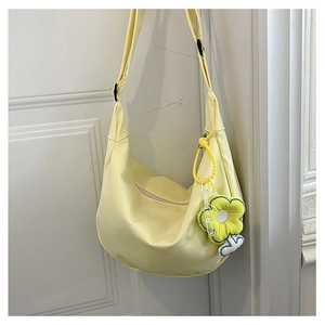 Détail du sac croissant jaune pâle avec pendentif tournesol et bandoulière