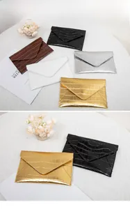 Detail view showing crocodile texture envelope clutch bags in black, brown, white and silver