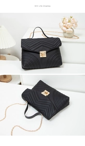Detailed view of black quilted crossbody bag featuring golden twist lock and chain strap