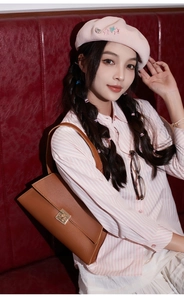 Gros plan détaillé du sac baguette en cuir marron texturé avec boucle dorée carrée
