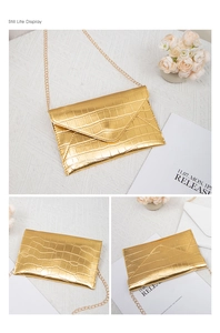 Detailed view of golden crocodile textured envelope clutch with metal chain strap