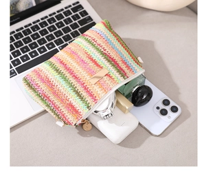 Vue détaillée d'une pochette tissée colorée montrant le rangement intérieur des accessoires