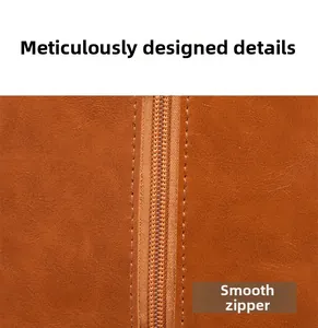 Detail of smooth metal zipper and reinforced stitching on brown faux leather bag