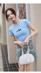 Close-up of white lychee-patterned Boston bag with fashion brand tag on strap