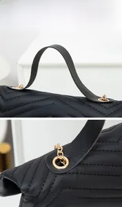 Close-up of V-quilted black leather handle and premium gold-tone metal hardware