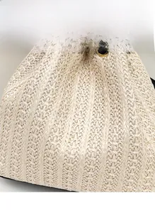Dettaglio della trama in paglia con coulisse nera e occhielli metallici sulla borsa