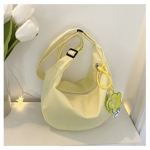 Détail du sac croissant en velours côtelé jaune clair avec breloque fleurie