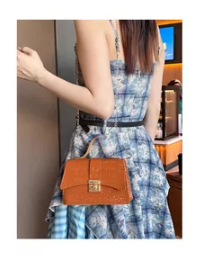 Detailed view of brown crocodile-textured PU leather bag with gold chain strap