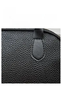 Close-up of premium black lychee leather handbag showing detailed stitching and texture
