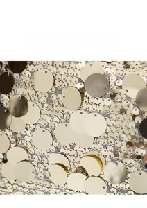 Detailed view of shimmering gold sequins on white mesh fabric for lightweight bags