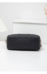 Detail view of black rectangular crossbody bag with diamond grid quilting and gold hardware