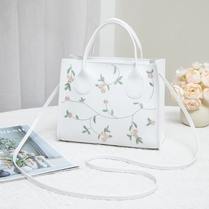 White floral embroidered square handbag with top handles and adjustable shoulder strap