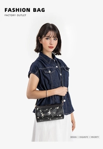 Detaillierte Nahaufnahme einer schwarzen Zylindertasche mit Blumenstickerei am Modell
