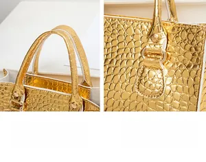 Detailansicht der goldenen Handtasche mit Krokodilprägung und verstärkten Griffen mit Nieten