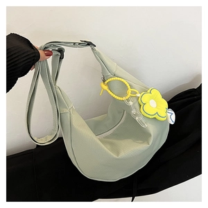Détail du sac bandoulière en velours côtelé vert clair avec breloque fleur et chaîne