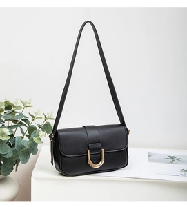 Detail der schwarzen Handtasche aus Kieselleder mit stilvollem goldener U-Verschluss