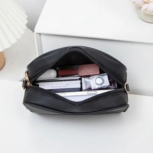 Classic black leather semi-circular cosmetic bag with spacious interior storage for makeup